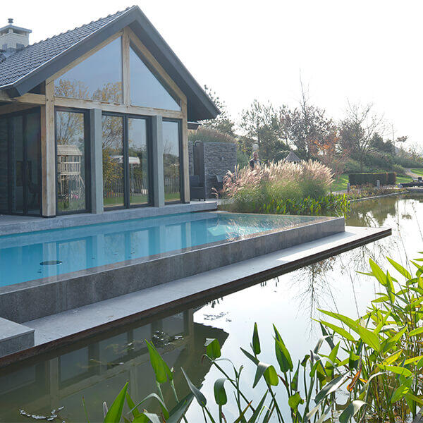 Tuin met maatwerk infinity pool en royale vijverpartij